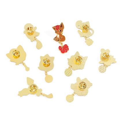 Gold enamel pins with a central round gemstone and leaf-like designs on a white background Pokemon