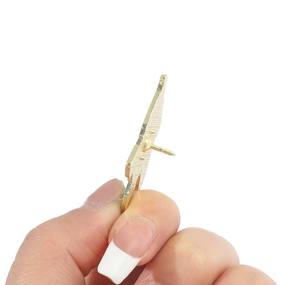 Hand holding a small enamel pin on a white background