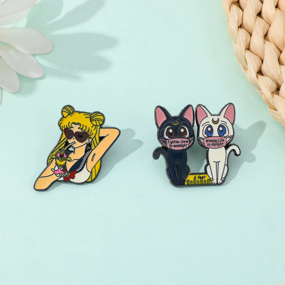 Three anime-style pins featuring a character from sailor moon anime, a black cat, and a white cat on a light blue background.
